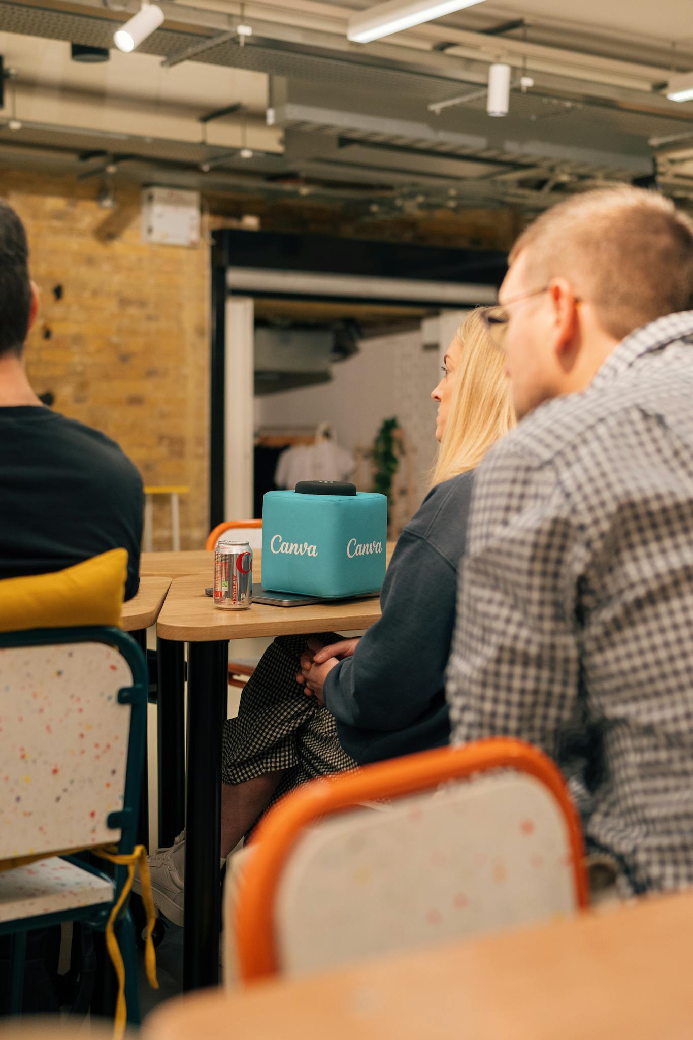 Individuals sitting in a creative workspace setting, engaging socially.